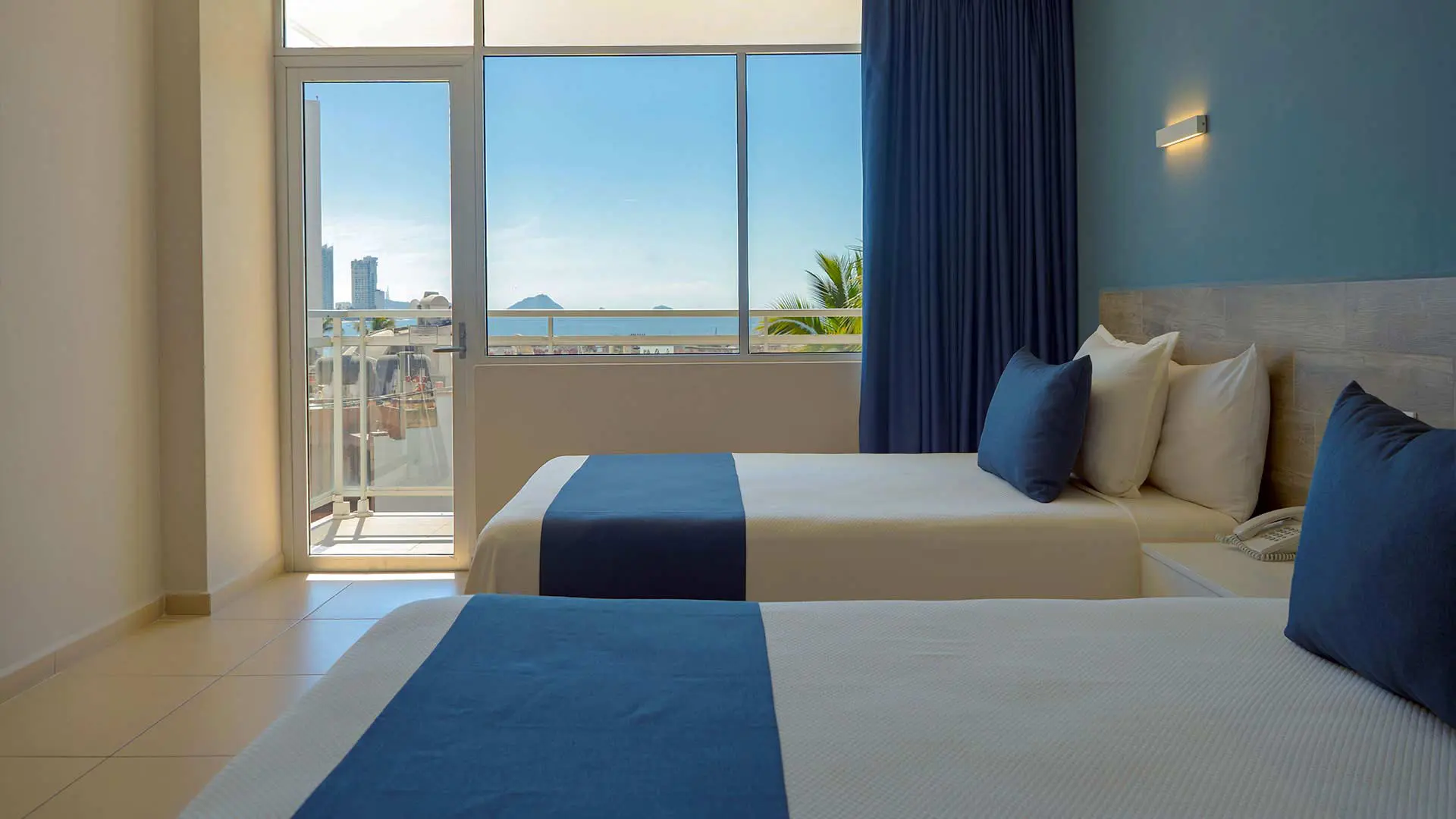 Room with two double beds and partial city view at Hotel Star Palace Mazatlán